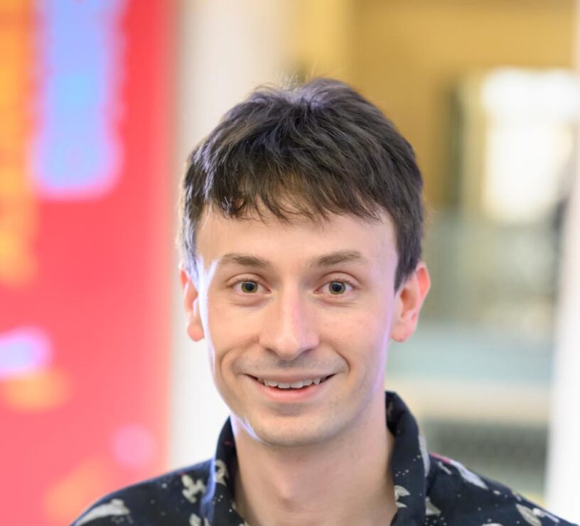 man with short brown hair and distant blurry background