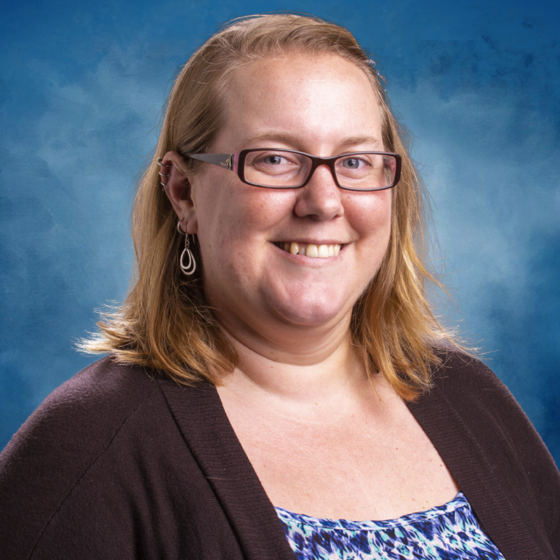 Blond woman with glasses in front of blue background
