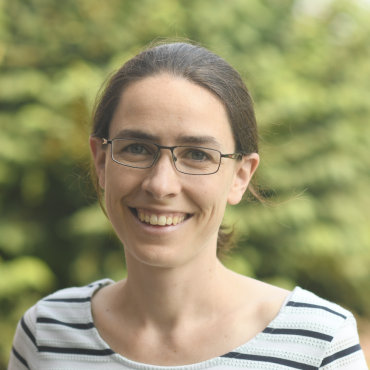 Meredith Hughes; woman with brown hair, glasses, striped shirt