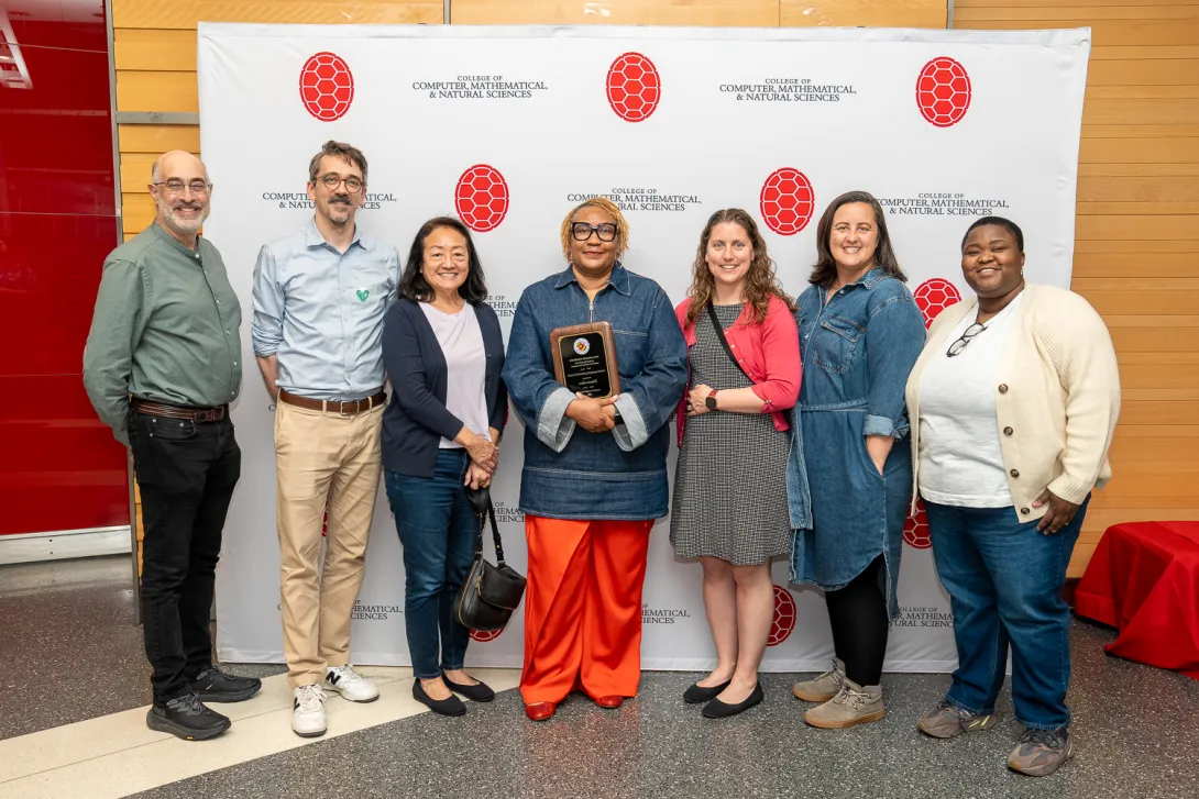 Anisha Campbell and Terrapin Teachers team in front of CMNS branded backdrop