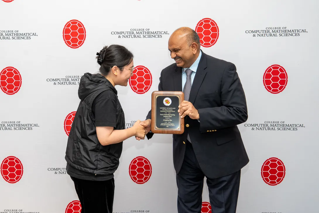 Mengting Chao shaking hands with Amitabh Varshney in front of CMNS branded backdrop