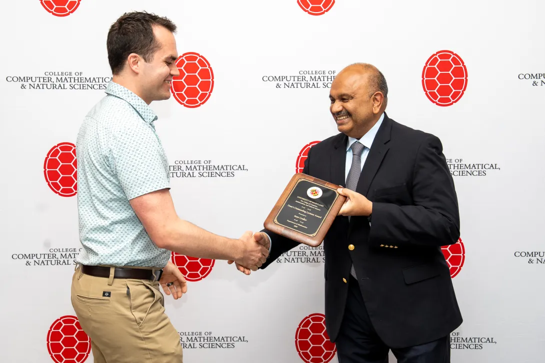 Sean Gruber shaking hands with Amitabh Varshney in front of CMNS branded backdrop