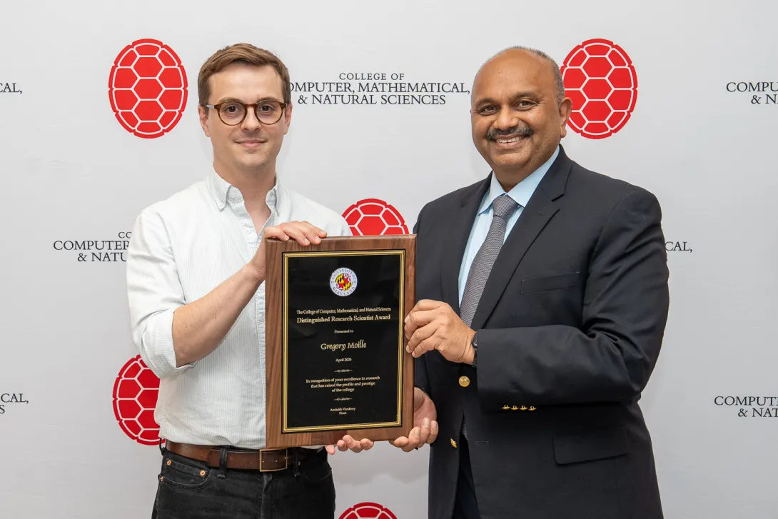 Gregory Moille and Amitabh Varshney holding plaque in front of CMNS branded backdrop