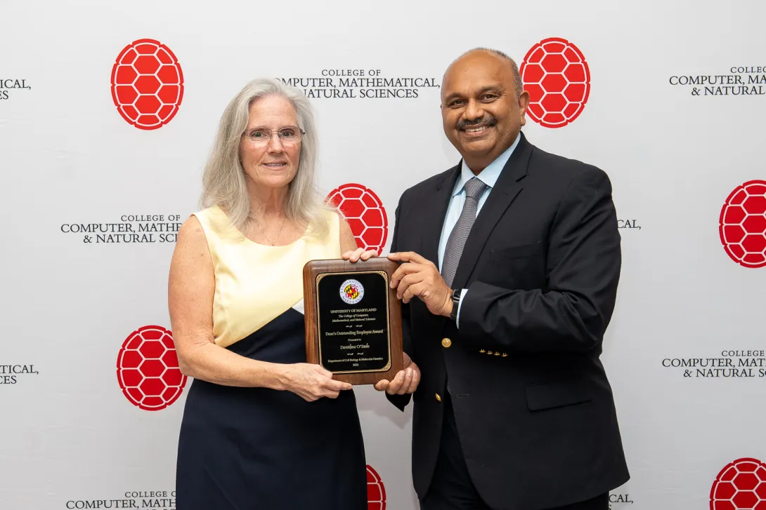 Dorothea O'Toole and Amitabh Varshney holding plaque in front of CMNS branded backdrop