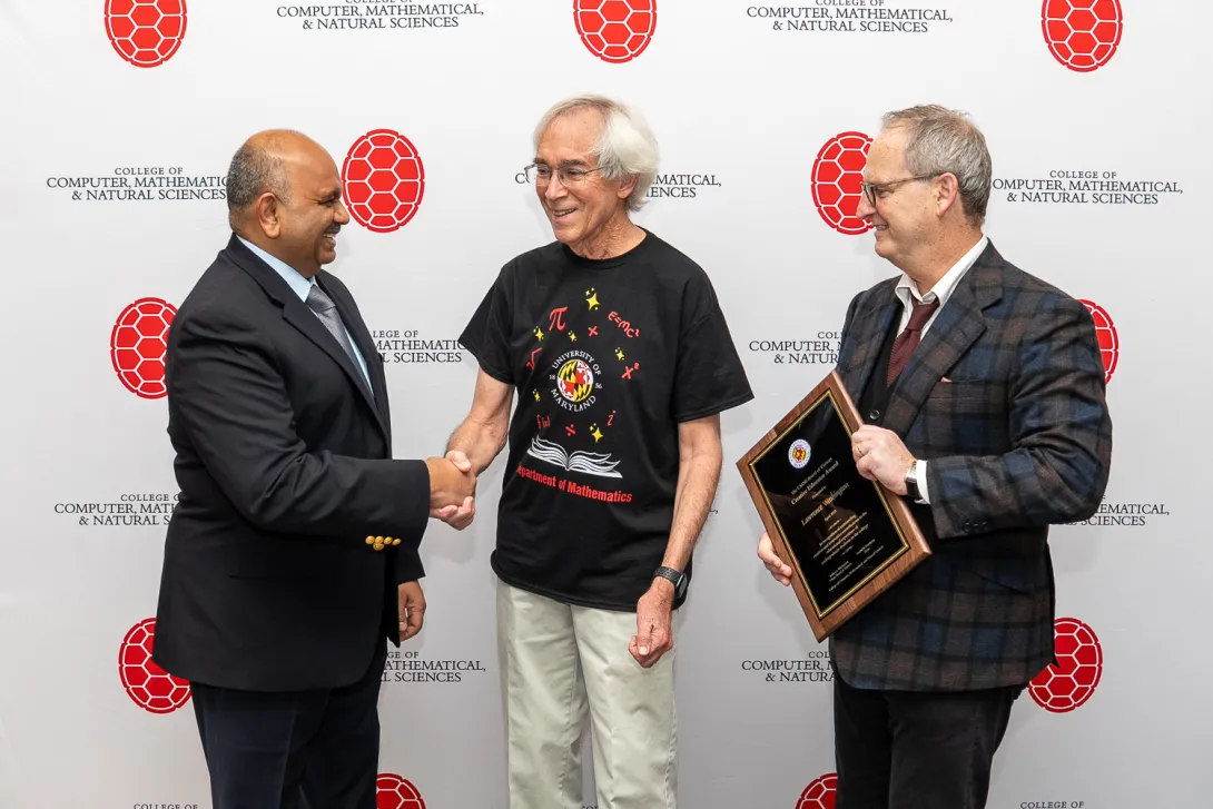 Lawrence Washington shaking hands with Amitabh Varshney in front of CMNS branded backdrop