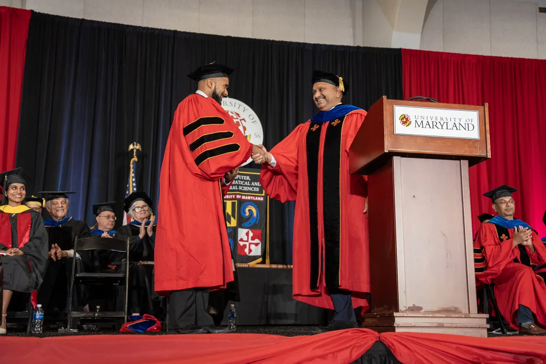 Graduate speaker Gabriel Grell shakes hands with Dean Amitabh Varshney