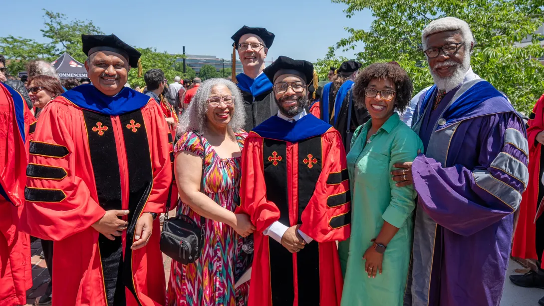 A family with a Ph.D. graduate and the dean outside of the Armory.
