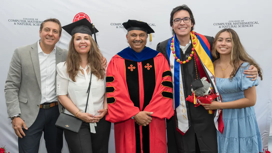 Dean Amitabh Varshney with a graduating student and his family.
