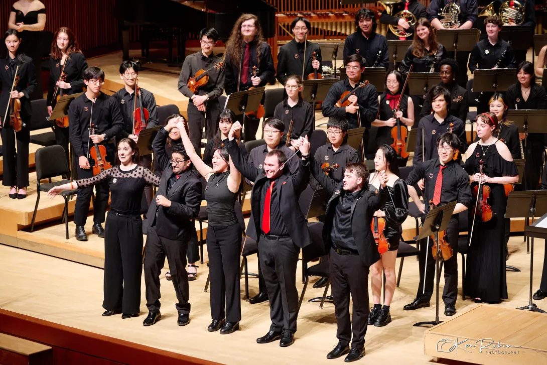 Performers prepare to bow on stage.