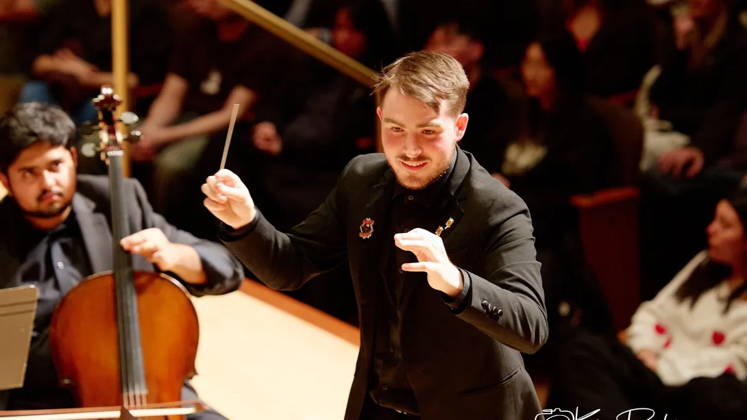 A male conductor conducts.