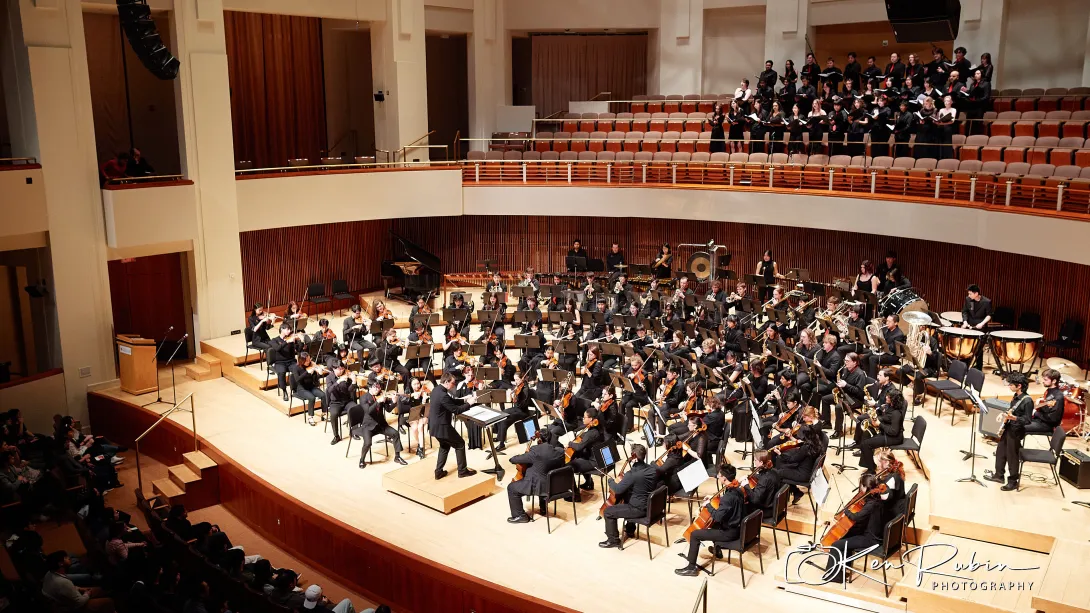 Full orchestra on stage and choir above.
